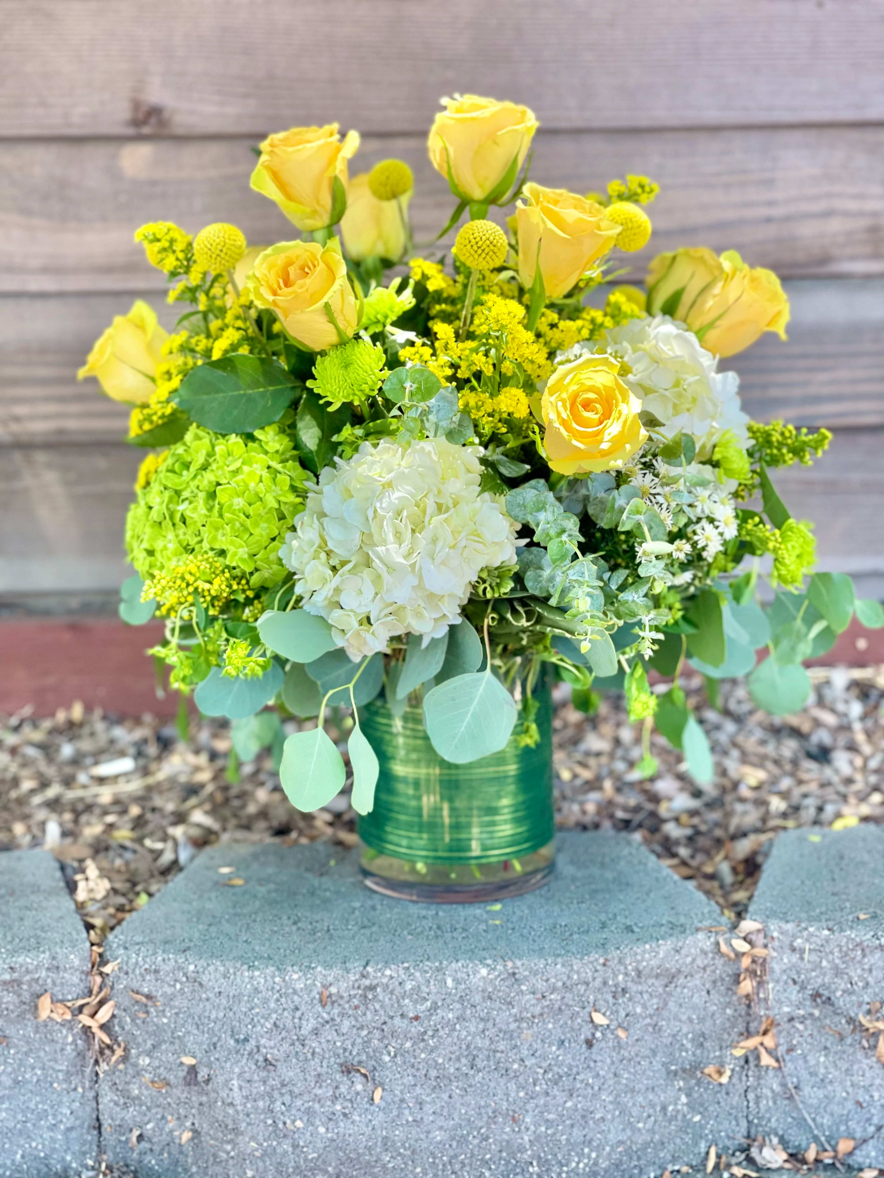 Cheers - Beautiful bright and cheery mixed of Premium Roses, hydrangea and a mix of season flowers to add a pop to the arrangement. In a clear glass leaf lined vase. 