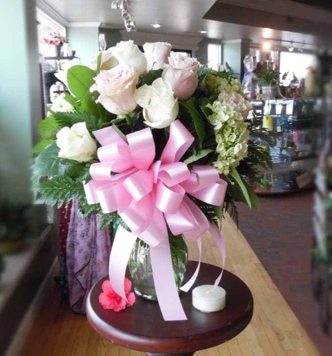 Precious Pastels - Make her blush today with this unique mix of flower. Let this arrangement light up her space and bring joy to every moment she gets to lay eyes on them.  It's not your usual dozen roses,this arrangement has a dozen roses six white, six light pink, and five green mini hydrangea. The orientation is all around approx 24 in tall and 12 in wide. 