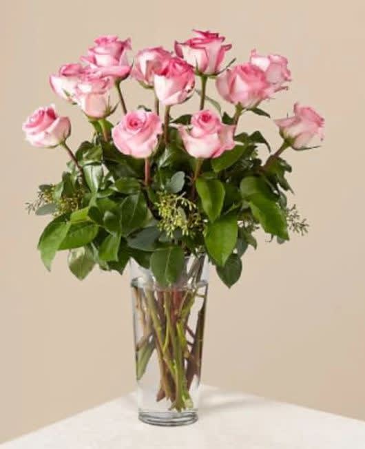 The Long Stem Pink Rose Bouquet - Picture-perfect soft pink roses make a beautiful gift for the lovely lady in your life. Wife, mother, daughter or sweetheart, she's sure to cherish this bouquet of pastel pink roses accented with seeded eucalyptus and arranged in a clear glass vase.This classic rose bouquet comes in 3 stunning sizes to fit any occasion! Whether it's to say that you're sorry, that you're in love or just because, this traditional bouquet of red roses and greenery is sure to do the trick! Available in 12, 18, or 24 count.  The Original Bouquet is approximately 18&quot;H x 12&quot;W.