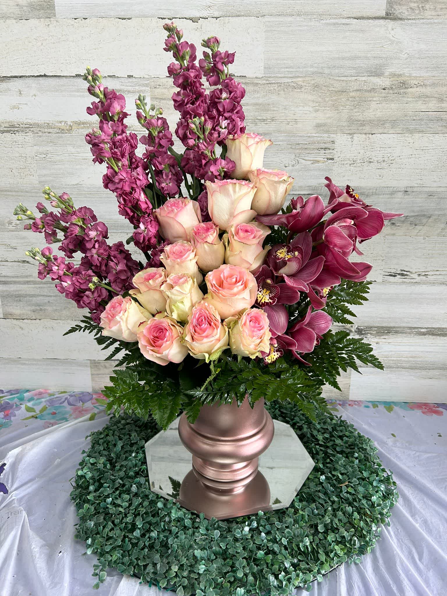 ELEGANT EXPRESSION ELEGANT EXPRESSION - GOLDEN VASE FILLED WITH ROES, CYMBIDIUM ORCHILD AND STOCK, PERFECTLY ARRANGE.