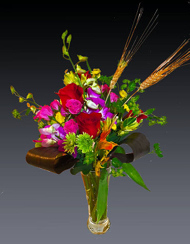 Your Majesty - Bountiful blooms including purple hydrangea, green cymbidium orchids, purple mokara orchids, lavender roses, wheat and green viburnum, green button spray mums and purple stock are elegantly mixed with greens, philodendron leaves and lily grass in a tall, footed flare vase. 