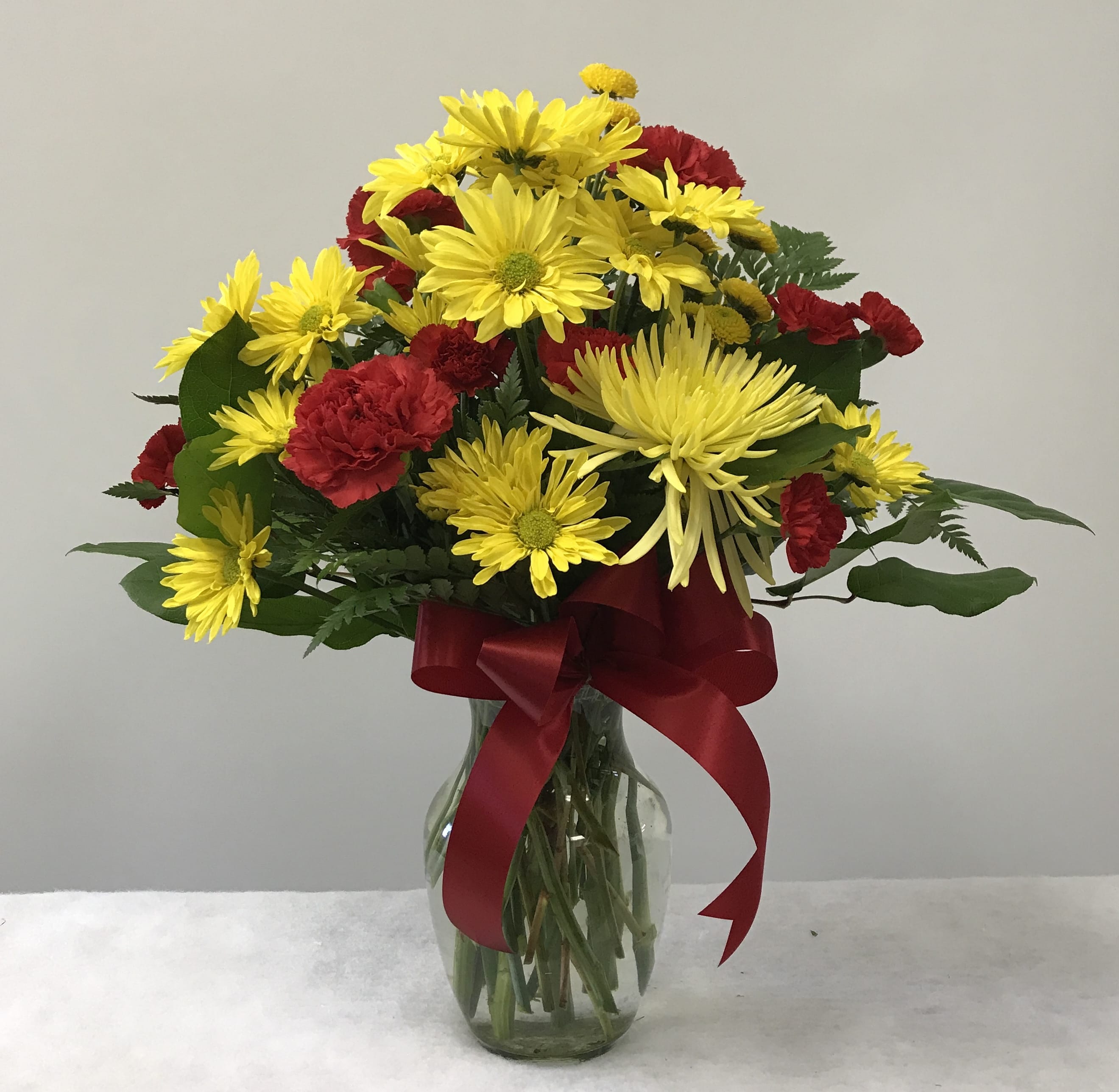 Kindest Heart Bouquet - A special show of kindness, on any day of the year! This eye-catching arrangement of red carnations, yellow daisies and chrysanthemums will surprise and delight your special someone - and remain a treasured memory for years to come. You may wish to substitute white for the yellow.  Just make a note in special instructions or give us a call to place your order. Orientation:  All-around  
