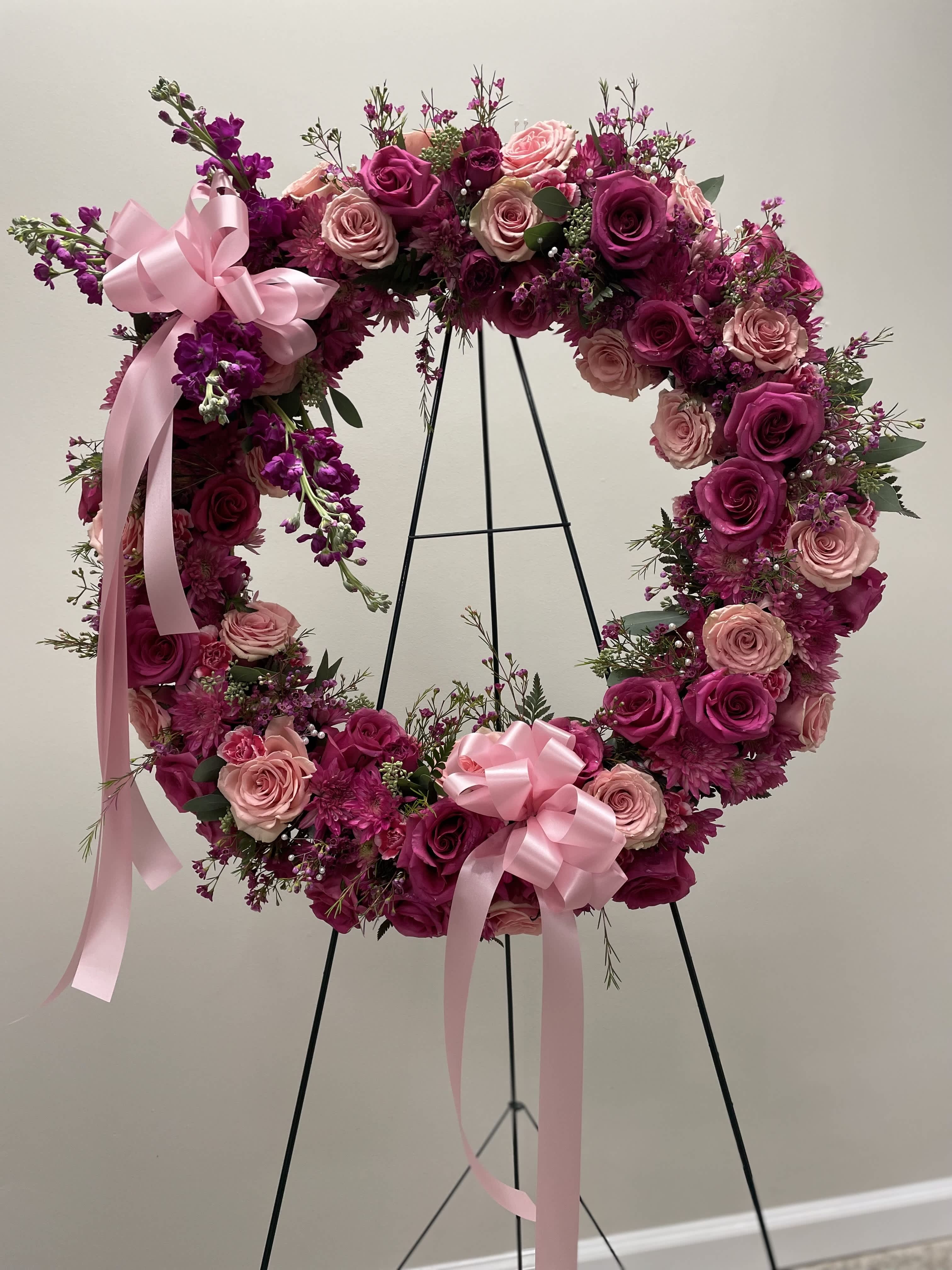 Pink Petal Embrace Floral Tribute - A stunning open circle standing spray adorned with various shades of pink roses, chrysanthemums, and stock flowers. Each delicate bloom radiates warmth and affection, symbolizing the love and admiration shared with your cherished one. As the gentle hues blend seamlessly together, this exquisite arrangement serves as a heartfelt tribute to celebrate a life filled with love, grace, and cherished moments. Let its ethereal beauty provide comfort and solace during this time of remembrance.