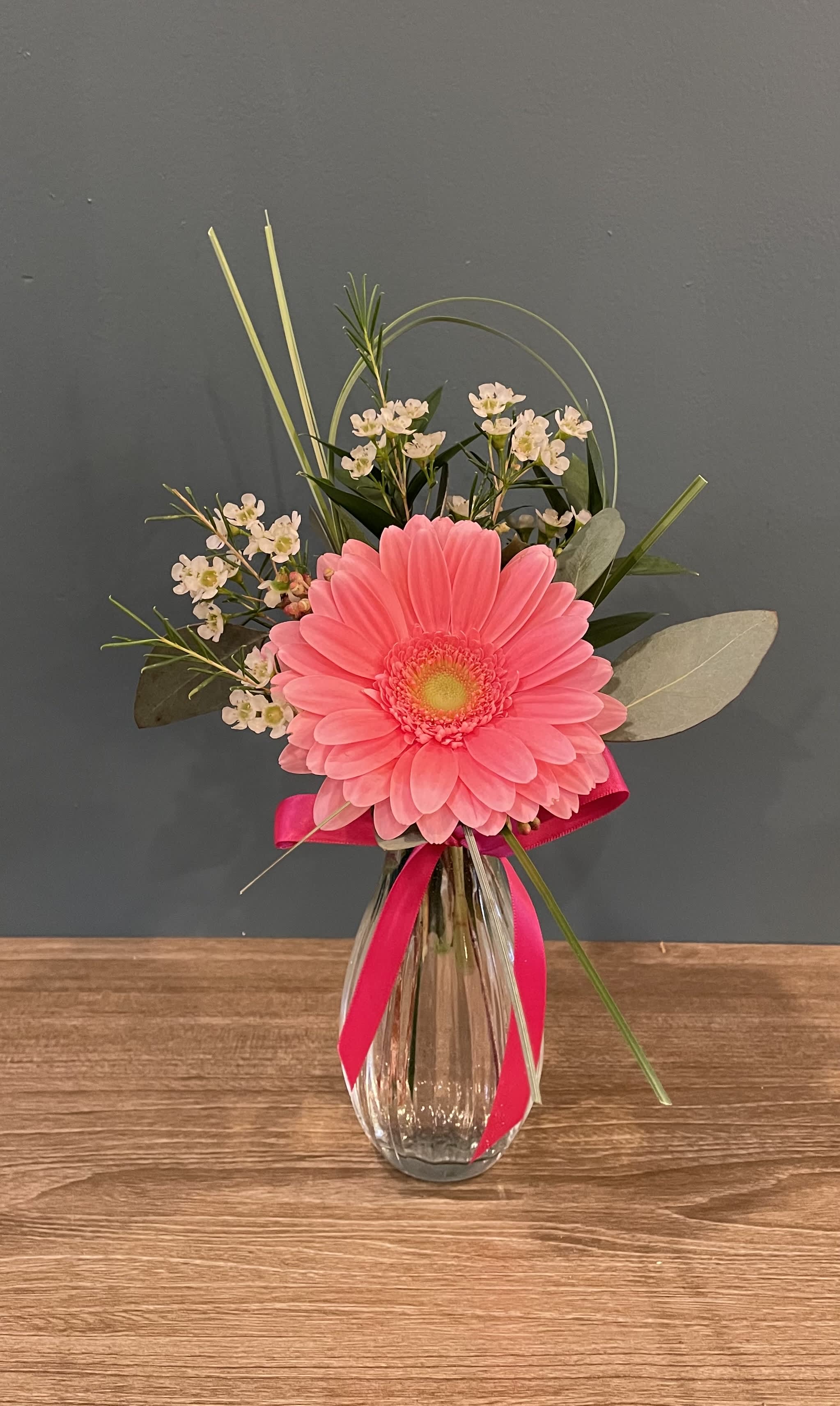 Just to make you smile Just to make you smile - A little something to say "Let me brighten your day", "Thank you" or "You're just the greatest!" With a fun bright colored gerbera daisy, in a small clear vase. (*Color of gerbera daisy are subjected to what is in stock at the store. )