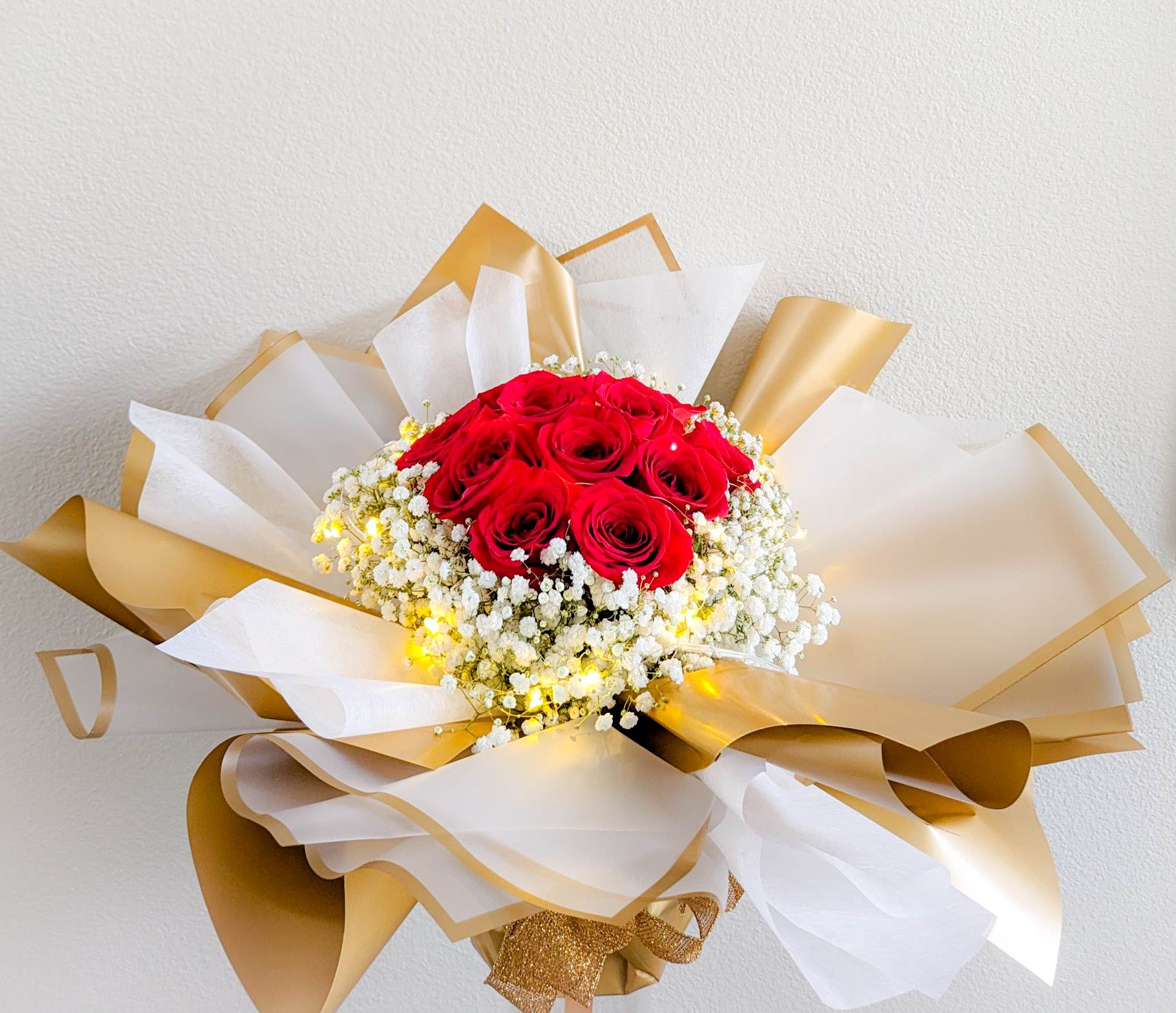 Illuminated Red Rose Bouquet  - 1 dz. red roses surrounded with baby's breath, arranged in a 6&quot;x6&quot; glass cylinder vase, wrapped in layers of jelly film and cotton paper, and illuminated with LED fairy lights.