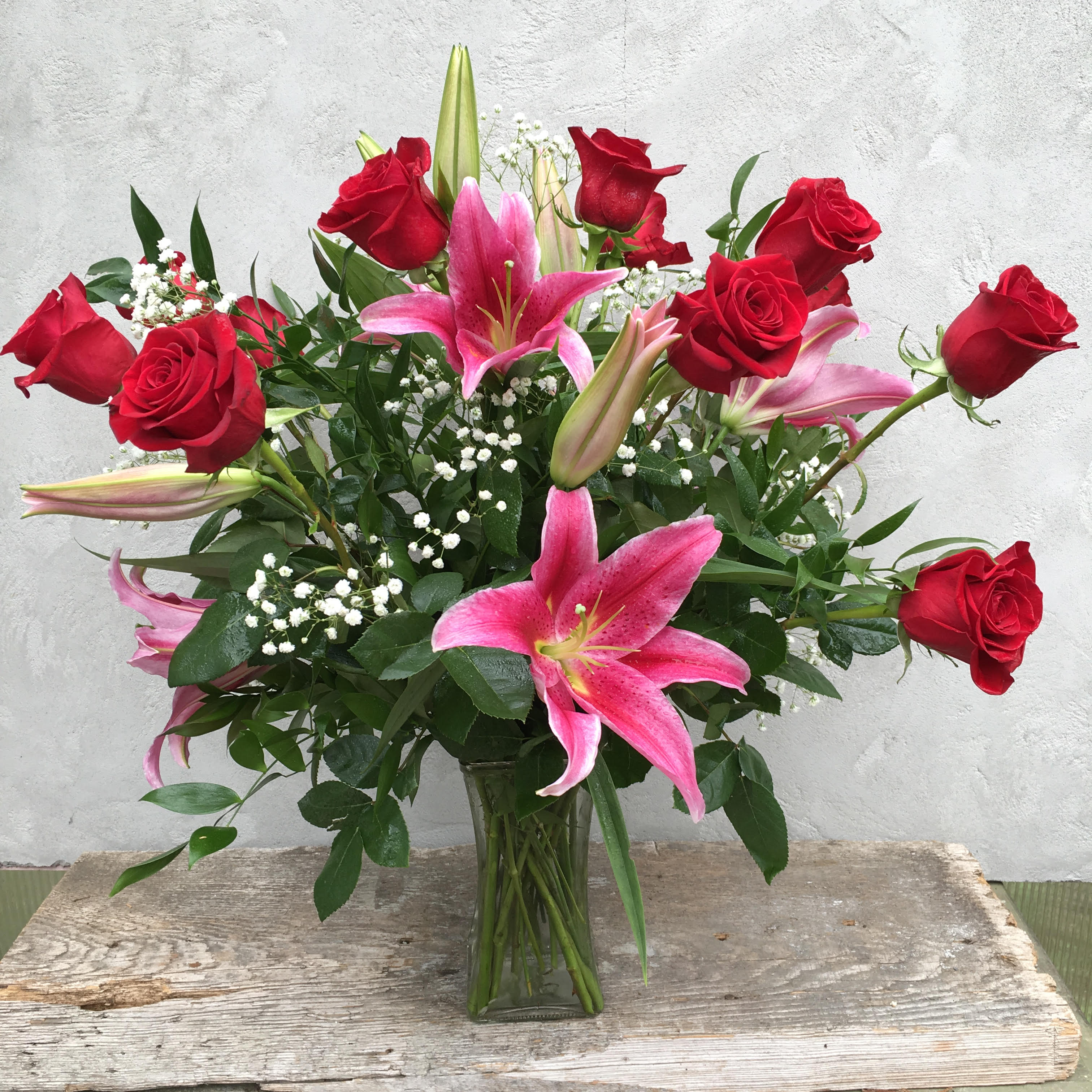 12 Premium Red Roses with 3 Lillies - 12 Premium red roses with greenery and stems of luxurious lilies and wax flower. *Substitutions may be applied*