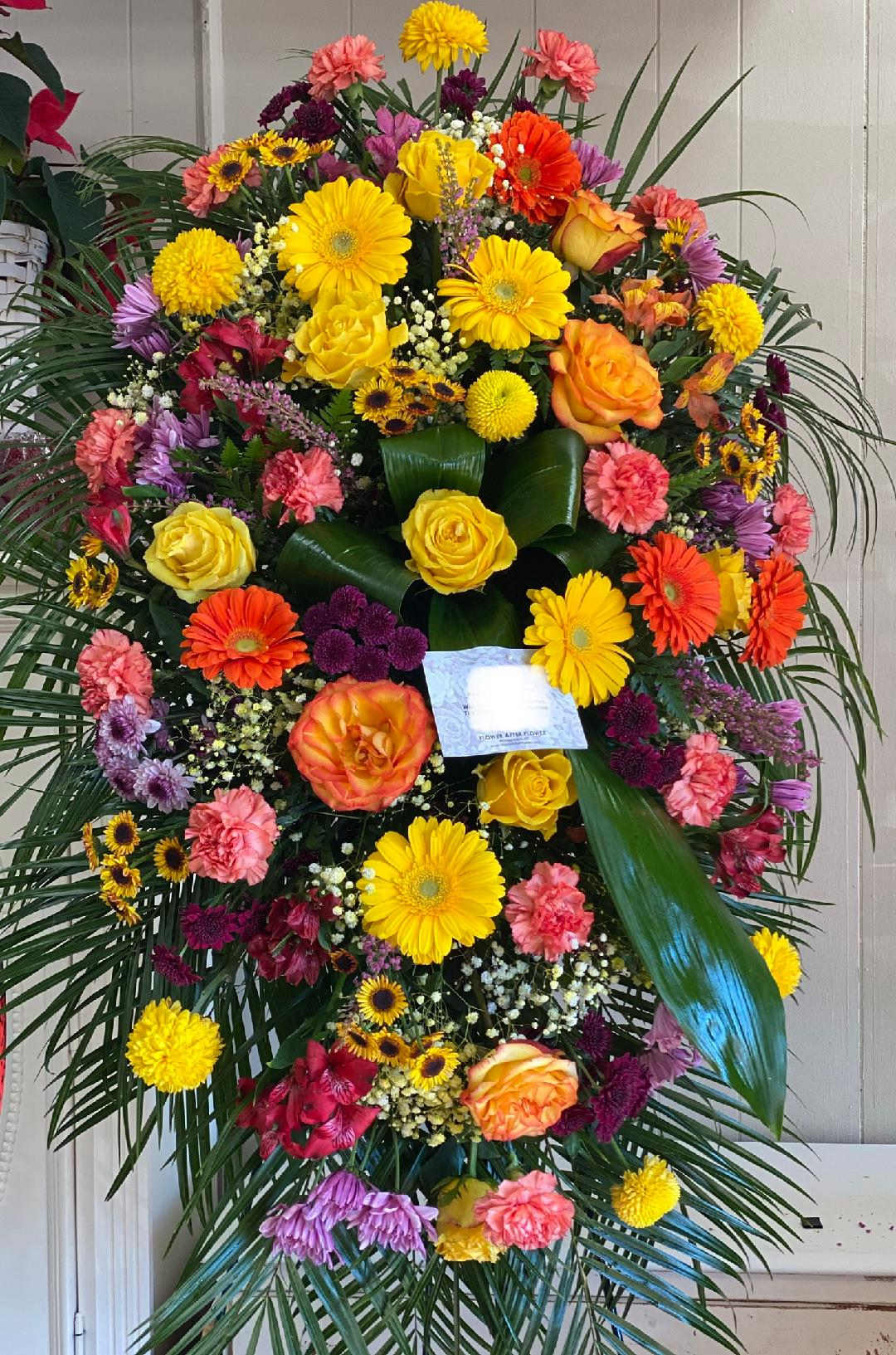 Celebration of Life Celebration of Life - One standing spray arrives with orange gladioli and roses, yellow gerberas, hot pink asters and foliage accents on an easel. Approximately 18" W x 46" H. TF203-8