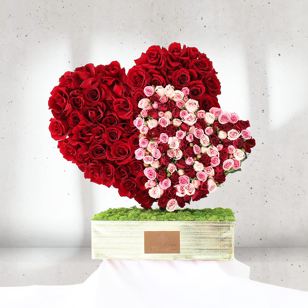 Love's Eternal Embrace - Surrender to the tender embrace of &quot;Love's Eternal Embrace,&quot; a captivating flower arrangement that embodies the timeless bond of affection. Crafted in the shape of two intertwined hearts, this enchanting display is adorned with a lavish assortment of red and pink roses.  The rich, velvety red roses symbolize deep passion and undying love, while the soft, blush-pink roses represent admiration and tenderness. Together, they create a harmonious symphony of emotions, capturing the essence of heartfelt affection and eternal devotion.  Perfect as a gift to express your love on special occasions, anniversaries, or to surprise someone dear just because, &quot;Love's Eternal Embrace&quot; becomes a true centerpiece of adoration and sentiment.