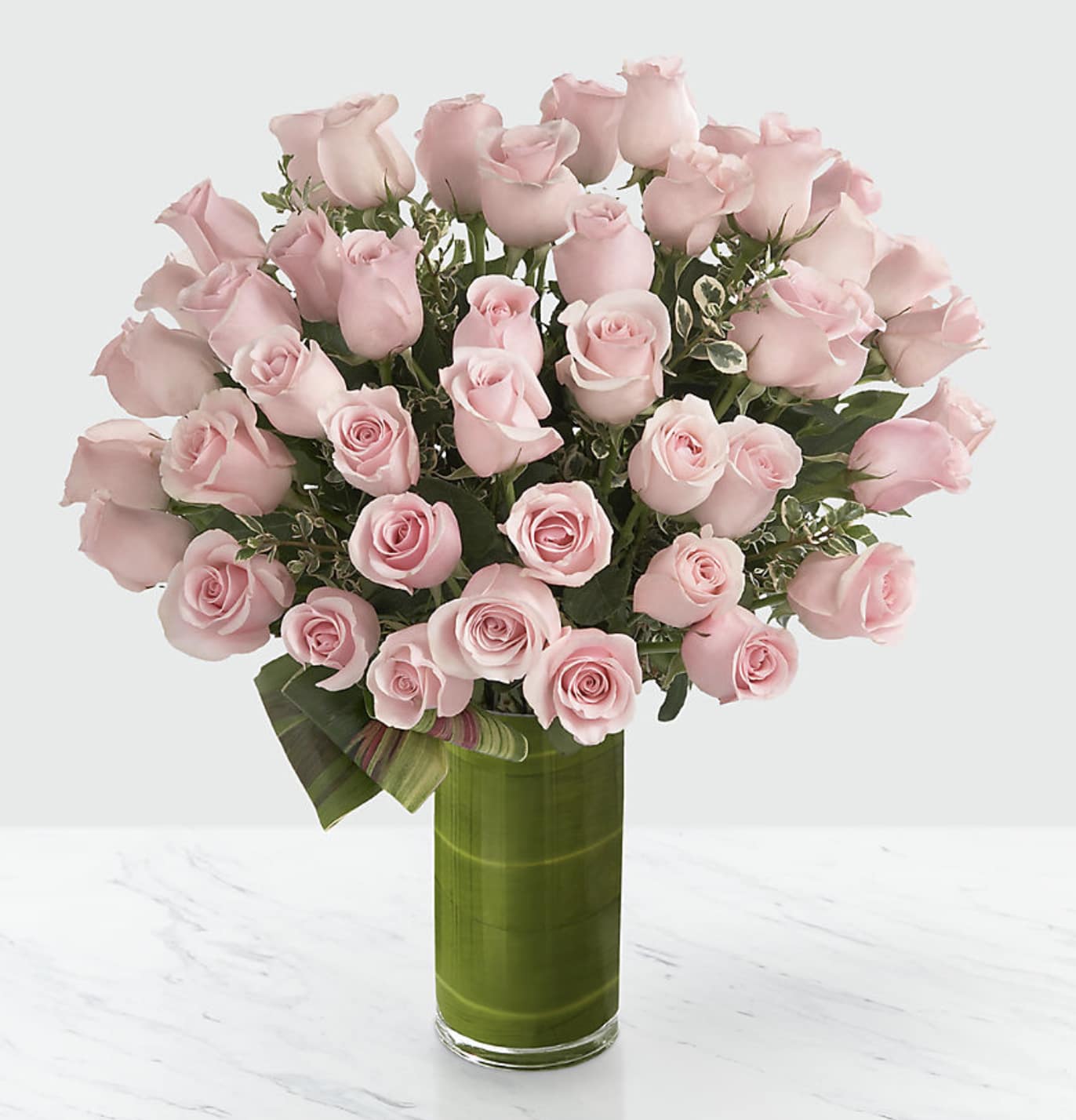Delighted Luxury Rose Bouquet - 48 Premium Long-Stemmed Roses - They've guided you through every pivotal moment in your life. Your only wish is to create as much pleasure as they have continually done throughout the years. Offer them our pale pink 48 premium long-stemmed rose bouquet situated in a superior clear glass cylindrical vase to create a moment of delight and blushing radiance they will never forget. Includes: 48 stems of pink  premium long-stemmed roses, exotic foliage 