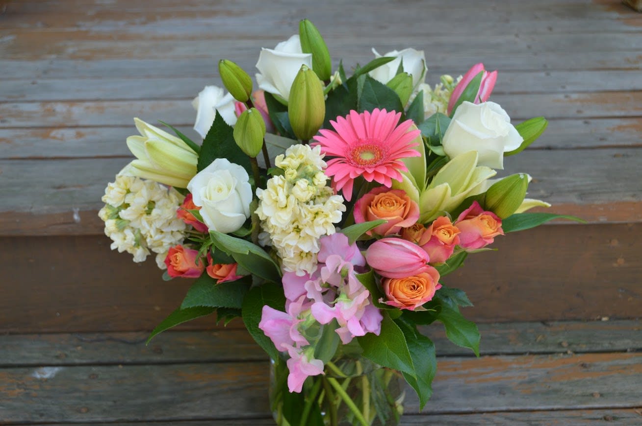 Spring Garden Mix - Gerbera daisy, spray roses, white roses, stock, tulips, lilies arranged in a pretty glass vase 