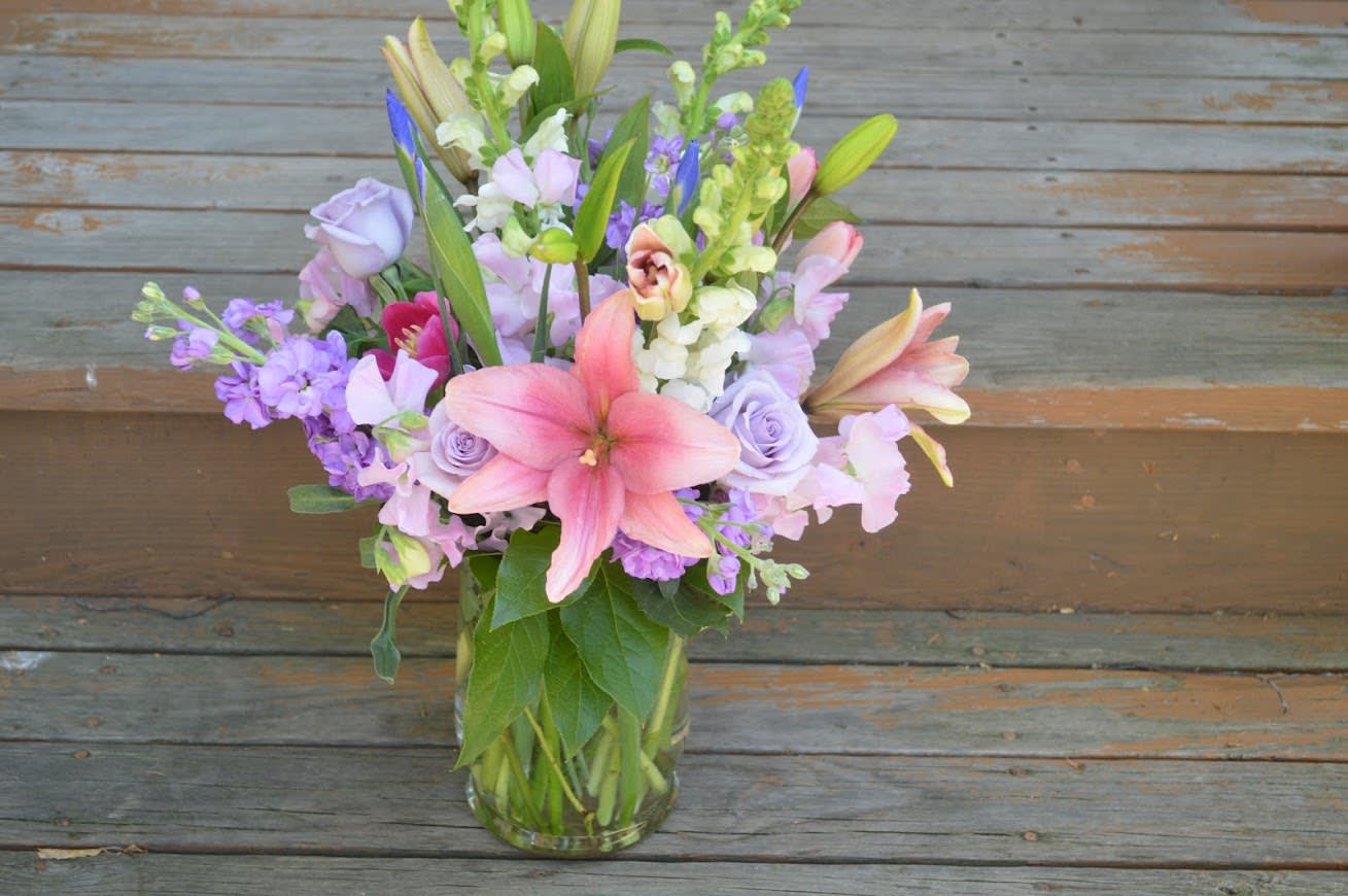 Pastel Vased Arrangement - A lovely lavender rose, lavender stock and pink toned arranged in a clear vase. 