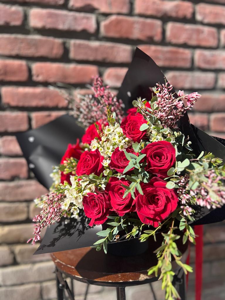 valentines hand tied bouquet - 1 dozen red roses with wax flower ginestra flower  and a variety of green deluxe [18 roses],premium [ 24 roses]