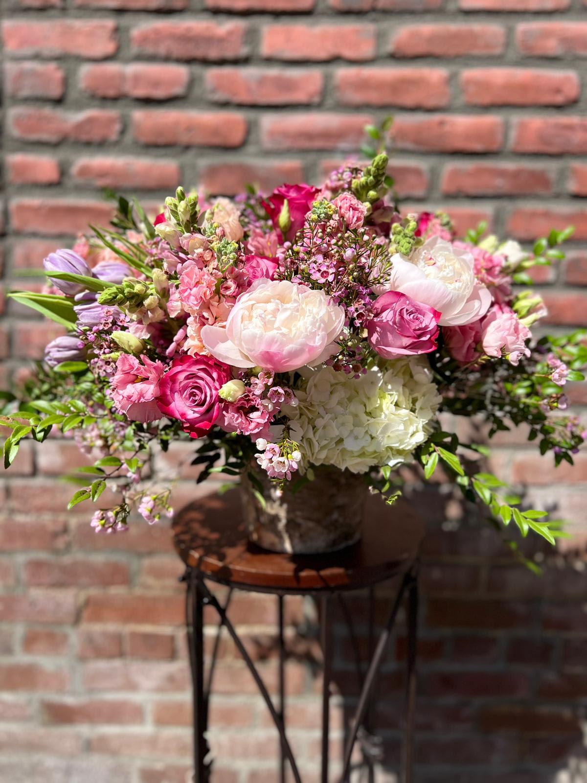 Girls Trip Girls Trip - composed of white hydrangea , wax flower, tulips, snap dragons, lisianthus, peonies , roses and stock in a gold pedestal container