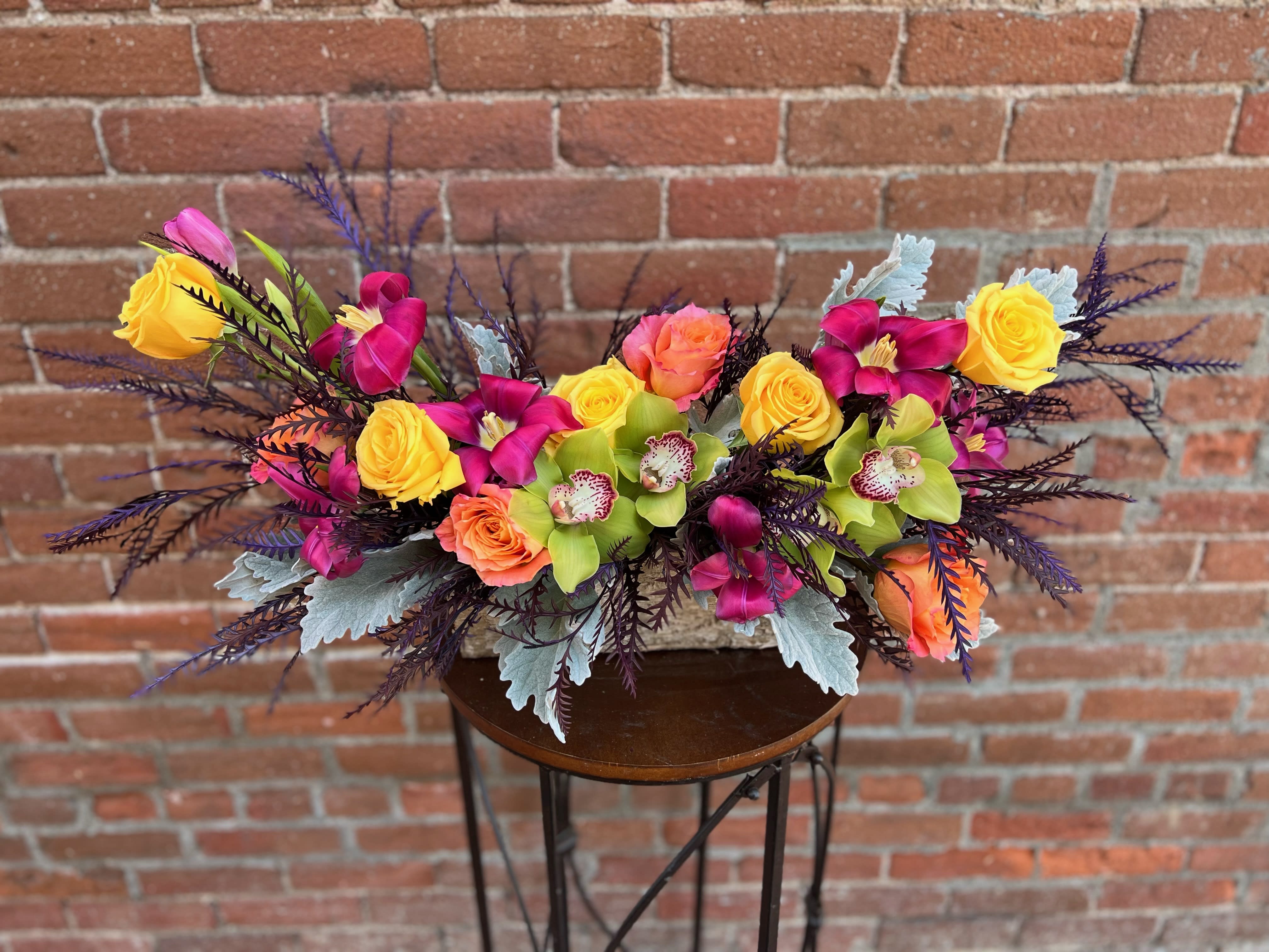 vibrant fall vibrant fall - a selection of fuscia tulips yellow and orange roses green cymbidium orchids and dusty miller and fall greens