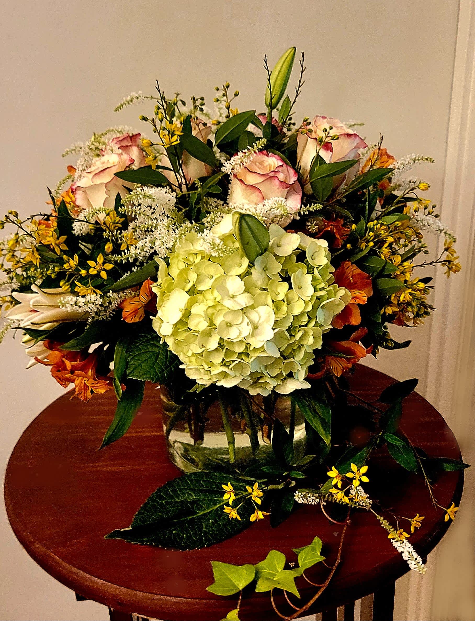 Perfect Blooms Perfect Blooms - This timeless and airy arrangement is a collection of in-season flowers that can be customized. This bespoke arrangement contains roses, hydrangeas, lilies, alstroemerias, and other dainty filler flowers in a glass vessel to elevate its sophistication.