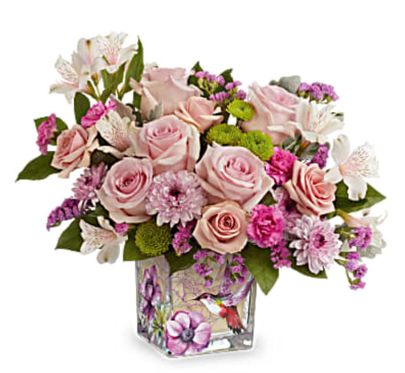 Hummingbird Surprise Hummingbird Surprise - A sweet surprise, this feminine rose bouquet is perfectly presented in a whimsical hummingbird-adorned cube vase.