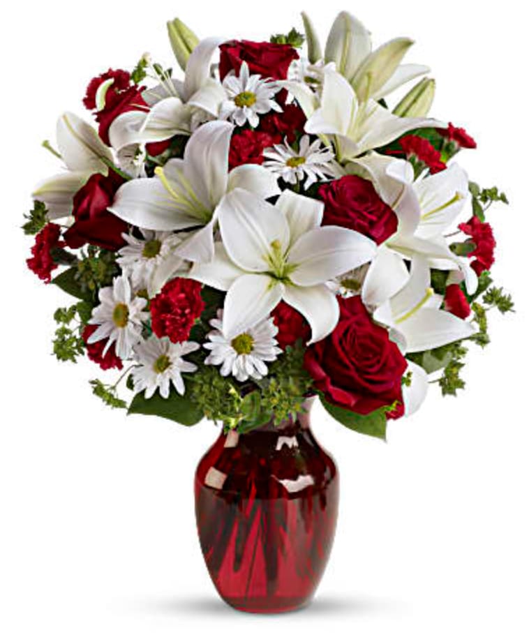 Be My Love - Add some romance to the holiday season with this rich arrangement of luxurious flowers in classic winter colors. Red roses, snow white lilies and playful daisies are gathered in a ruby red vase she'll use well beyond Christmas! 