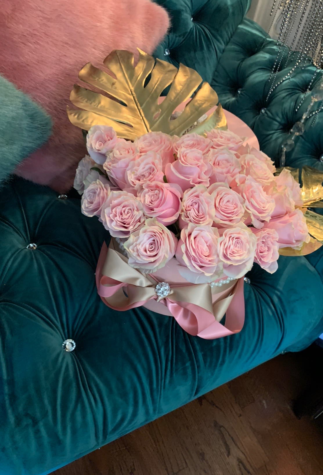 Pink Princesa  - A multitude of precious, soft-petalled, pink roses fit for a princess are charmed with regal, gold leaves adorning this arrangement while a string of faux pearls and brooch lend an elegant touch.