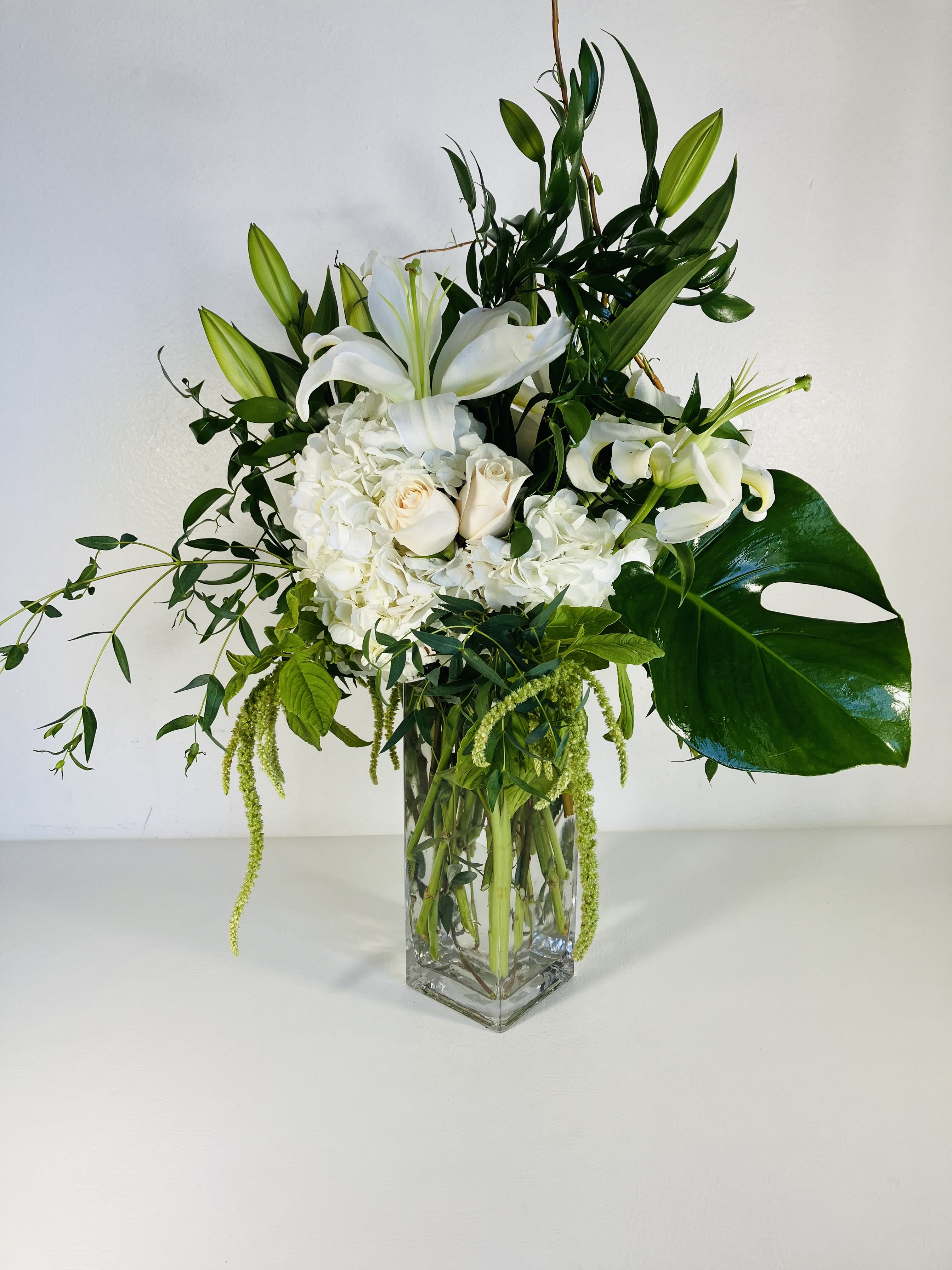 Lovely Lillies - Lillies hold great value to the world - throughout culture and literature they remain not only lovely but influential. This arrangement encompasses timeless beauty with prominent white lilies, white hydrangea, and italian ruscus. 