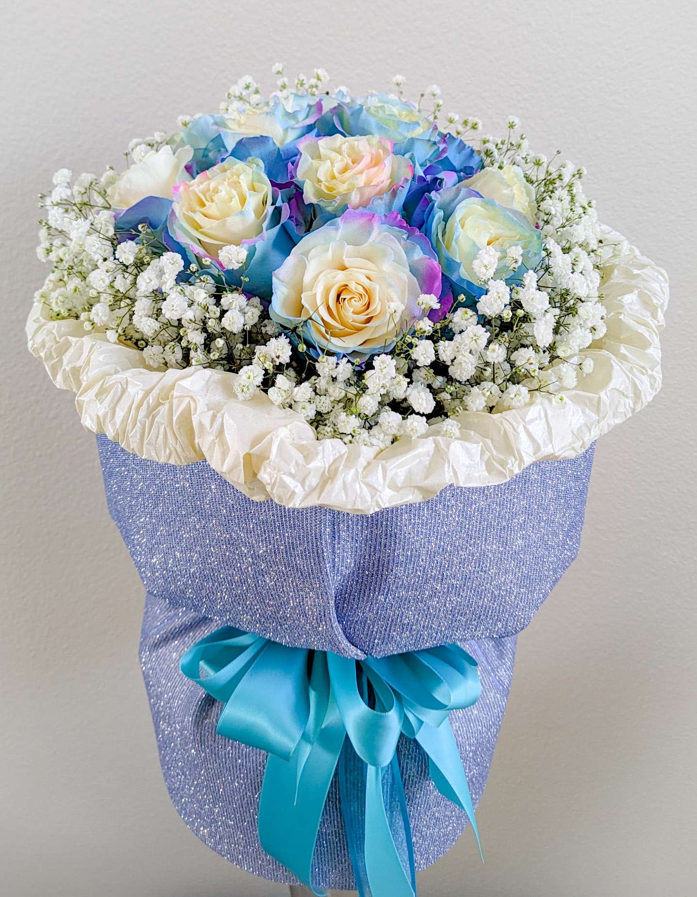 Aurora Chanel Style Bouquet  - 1 dz. Aurora-multi color roses surrounded by baby's breath, arranged in a 6&quot;x6&quot; vase and wrapped Chanel Style with shimmery fabric.
