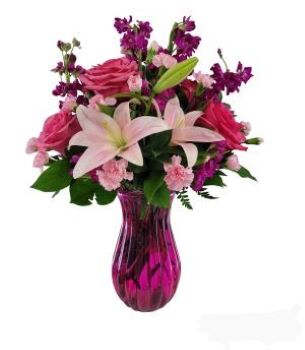 Bella - Make any big occasion bloom with beauty and happy memories to be cherished for a lifetime. This exquisite mixed flower bouquet captures the gorgeous essence of springtime with a fresh and lovely combination of pale pink Asiatic lilies and hot pink roses with lavender mini-carnations purple stock and more all hand- arranged in a pink glass keepsake vase.  Please note the vase being used will be either pink or purple.