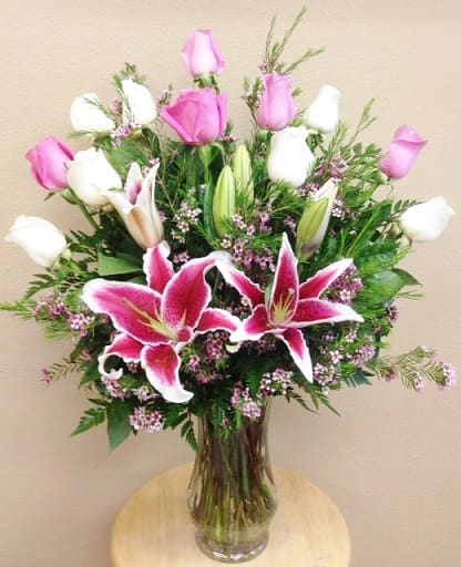Pink and White Roses with Lilies - 12 Roses (Pink and White) and Pink Lilies arrive beautifully arranged in a vase with greens and filler.