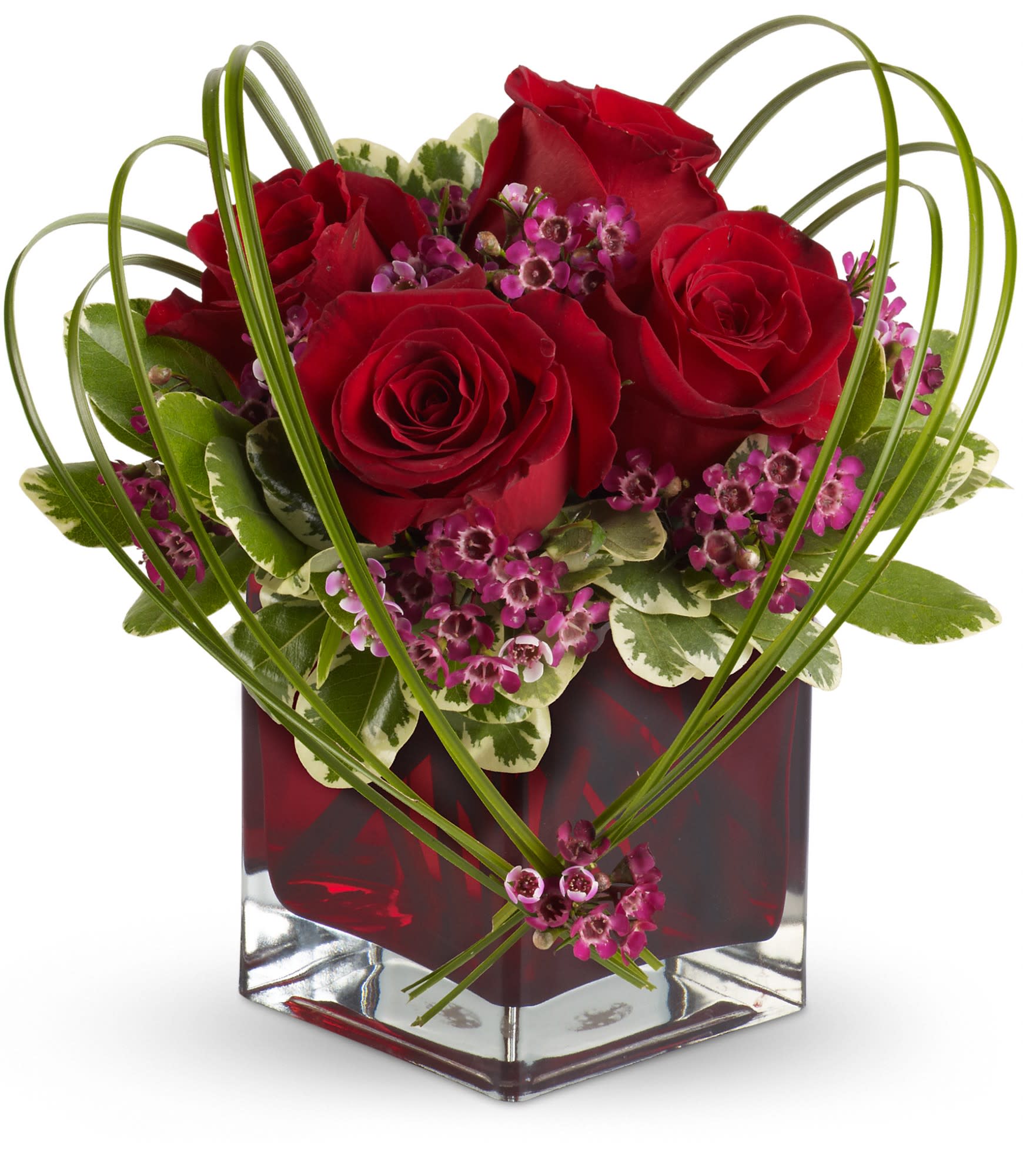 Teleflora's Sweet Thoughts Bouquet with Red Roses - A deluxe mix of red roses and purple waxflower - accented with bear grass and greenery - is delivered in a red glass Teleflora Cube vase.