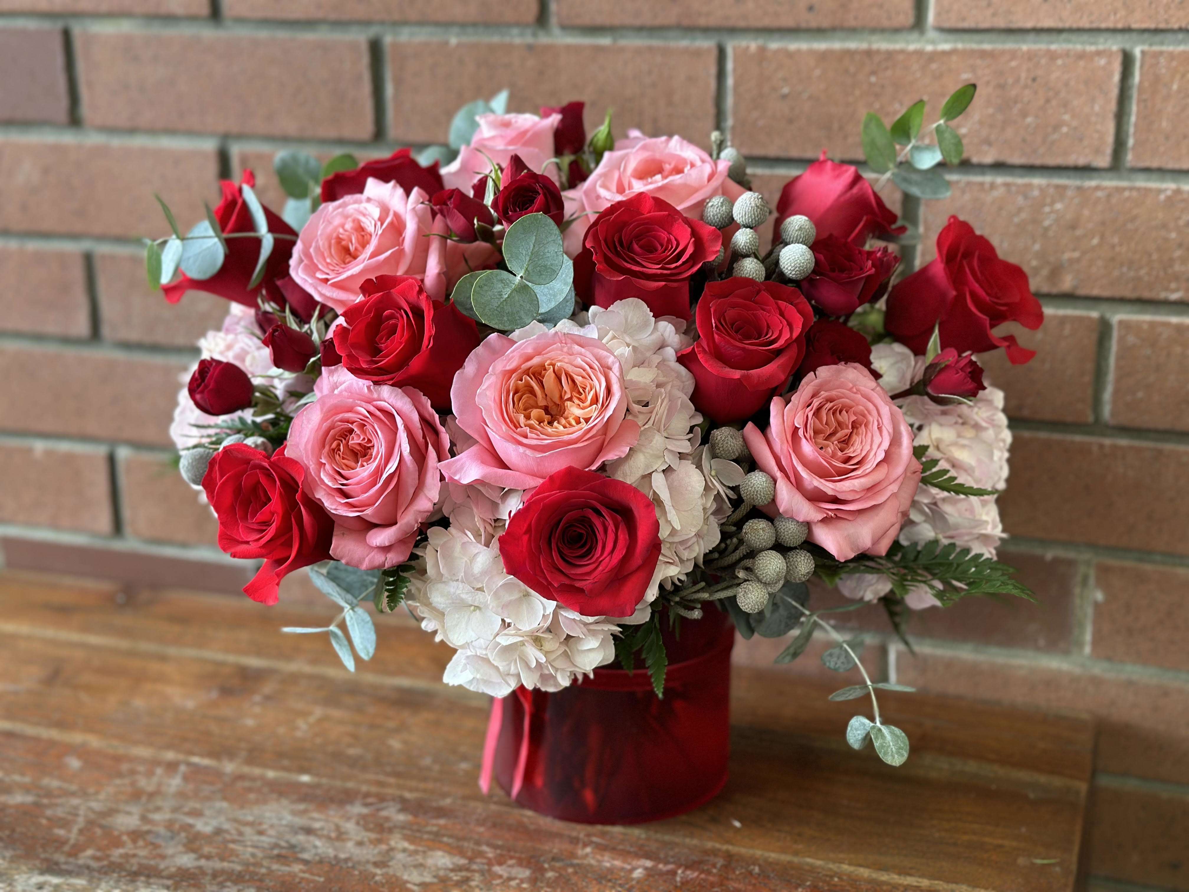 Be Loved Bouquet  - 18 Stunning Red &amp; Pink Garden Roses, Regular Roses, Spray Roses, Pink Hydrangeas, and Eucalyptus, in a small Red Cylinder Vase. 