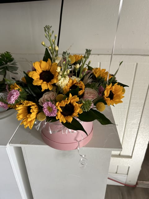 Sunny Elegance Sunny Elegance - Complementing the sunflowers are various filler flowers and greenery, such as delicate white flowers that add contrast and texture, and pinkish-purple chrysanthemums or similar blossoms providing a subtle splash of complementary color.