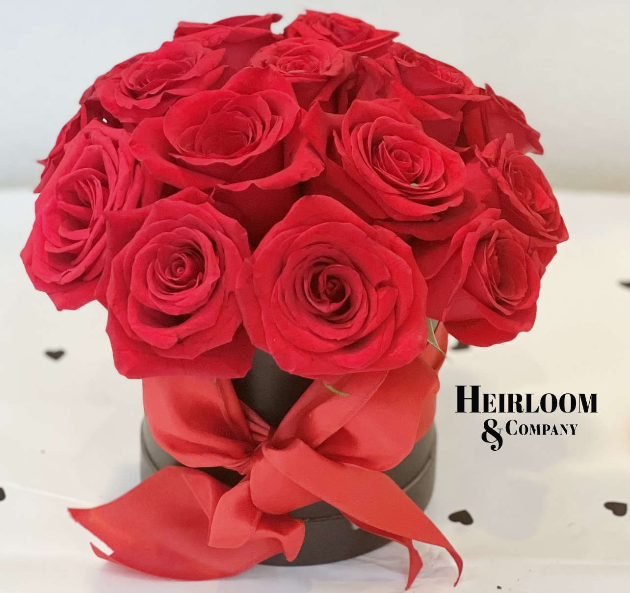 Ruby - A lovely black matte hatbox with our premium red roses, and a red fluffy bow.