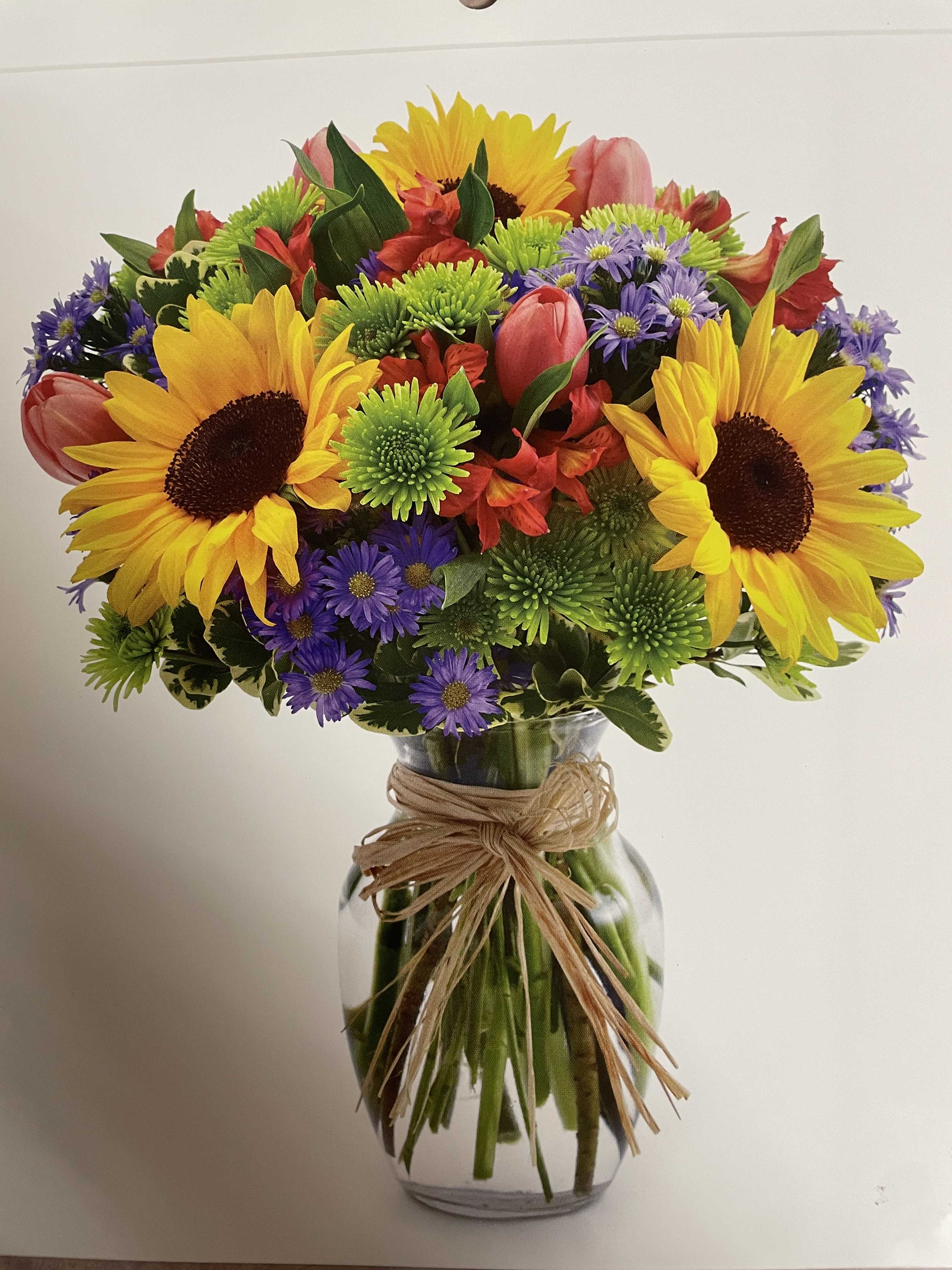 Daisy Garden - This beautiful bouquet is ideal for Grandparents, bosses, Cinco de Mayo, or other occasions. Contains: Sunflowers, tulips, alstroemeria, green buttons, Chester daisy, and foliage.  Standard price is 59.99.  Note:  Out of season flowers will be substituted.  It can be cutom made.  Custom made prices will vary.  For custom made orders, call the store.  
