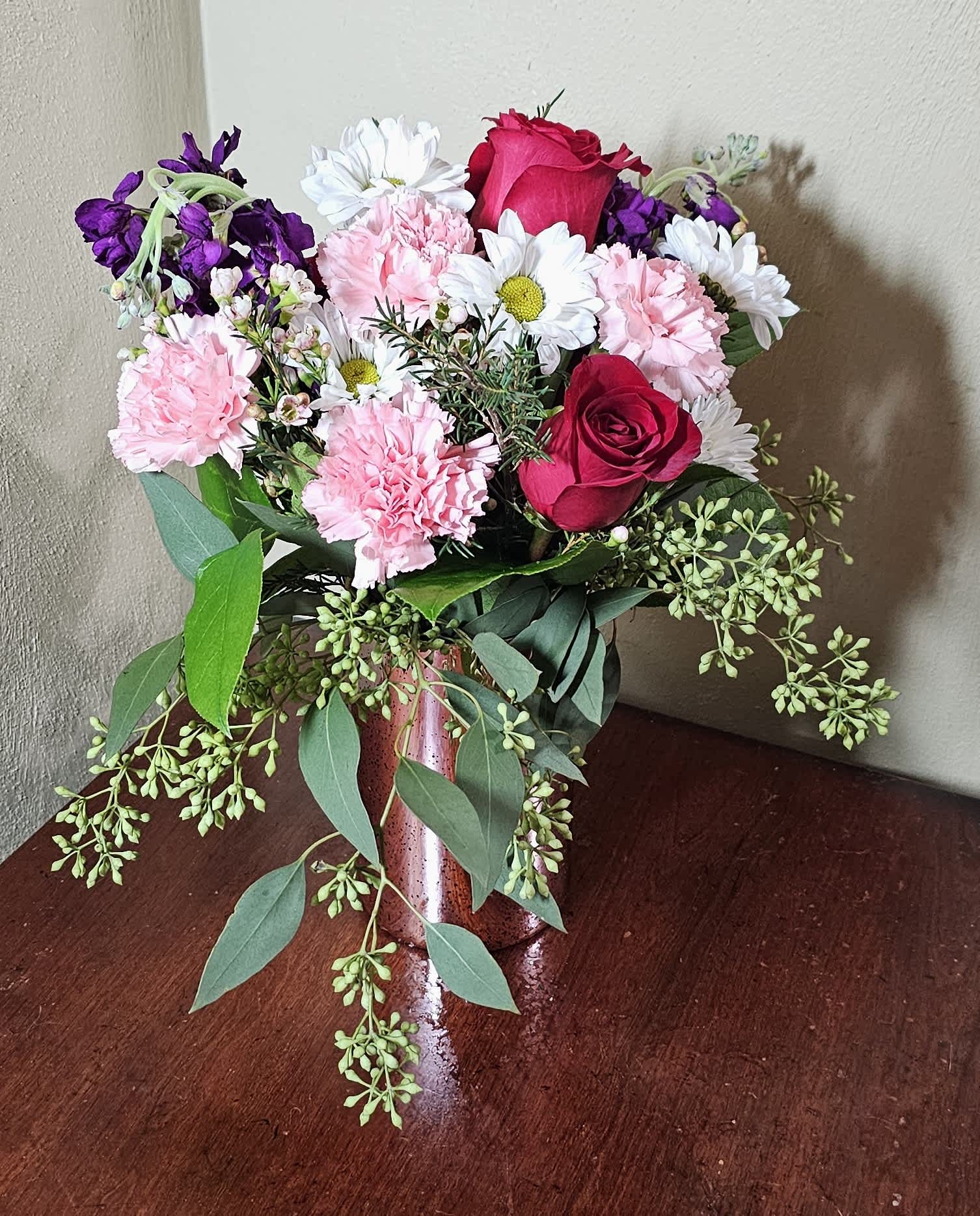 Blushing Beauty - Pink reflective vase with assortment of pink, white, and purple flowers.