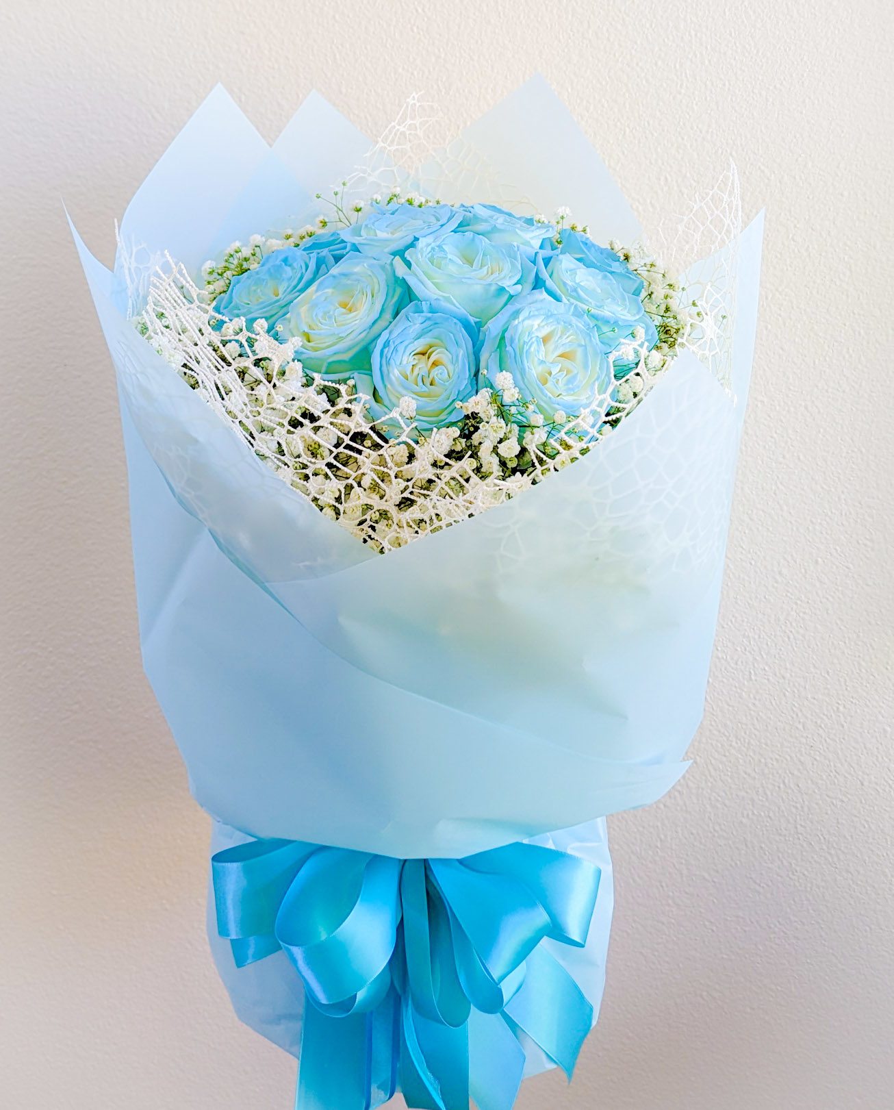 Ice Blue Chanel Style Bouquet Ice Blue Chanel Style Bouquet - 1 dz. Ice Blue roses surrounded by babies breath, arranged in a 6"x6"glass cylinder and Chanel Style wrapped.