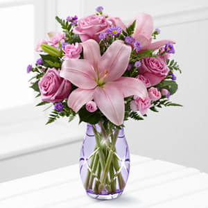 The Graceful Wonder Bouquet (This vase is sold out we will use a clear vase and a purple bow) The Graceful Wonder Bouquet (This vase is sold out we will use a clear vase and a purple bow) - The Graceful Wonder Bouquet blushes with floral beauty to send your special recipient your most heartfelt sentiments. Lavender roses and pink Asiatic lilies are surrounded by pink mini carnations and purple Monte Casino asters to create an incredible flower arrangement. Presented in a lavender glass vase this mixed flower bouquet will make the perfect impression on their birthday anniversary in celebration of the birth of a new baby girl or as a way to express your thanks and gratitude.