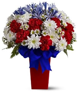 CF2083 - Patriotic Petals Celebrate the spirit of our country with this bold and beautiful red, white and blue bouquet. It makes a firecracker of a gift for anyone proud to be an American. Details: Blue agapanthus, white chrysanthemums and Monte Cassino Asters and brilliant red carnations are arranged in a perfectly patriotic pattern in a bright red tapered vase that is wrapped with a royal blue satin ribbon.