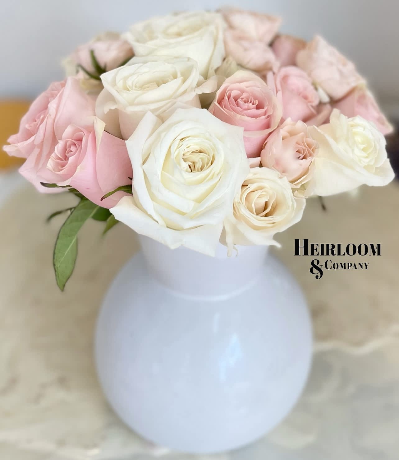Sweetheart Flower Arrangement  - An iridescent vase filled with our most premium white and blush garden roses and sprinkled with the most adorable peach spray roses to perfectly accent this soft sweetheart inspired palette.