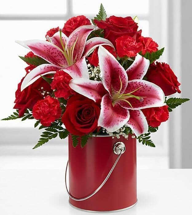 Color your day Red Color your day Red - Giving your special recipient a gift that reflects their own shining personality and charm. Rich red roses, eye-catching Stargazer Lilies, bright red mini carnations, million star gypsophila and lush greens are artfully arranged within a striking red quart size decorative paint can inspired vase to create an incredible gift they won’t soon forget.