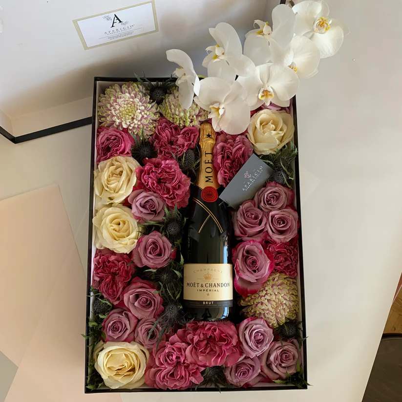 Floral Gift Box &quot;Spring in Marseille&quot; - Our Floral Gift Box &quot;Spring in Marseille&quot; is a luxurious and indulgent treat that captures the beauty and charm of the French Riviera. The stunning combination of Deep Purple and Full Monty Roses, accented with the soft and delicate petals of White Chocolate Roses, is expertly arranged by our skilled florists to create a mesmerizing display of colors that evoke the vibrant hues of a Mediterranean garden in full bloom. To complete the gift experience, we include a bottle of champagne or sparkling wine, adding an extra touch of sophistication and celebration. This Floral Gift Box is the perfect gift to bring a touch of springtime beauty and elegance to any home or office, and is sure to impress and delight anyone who receives it.