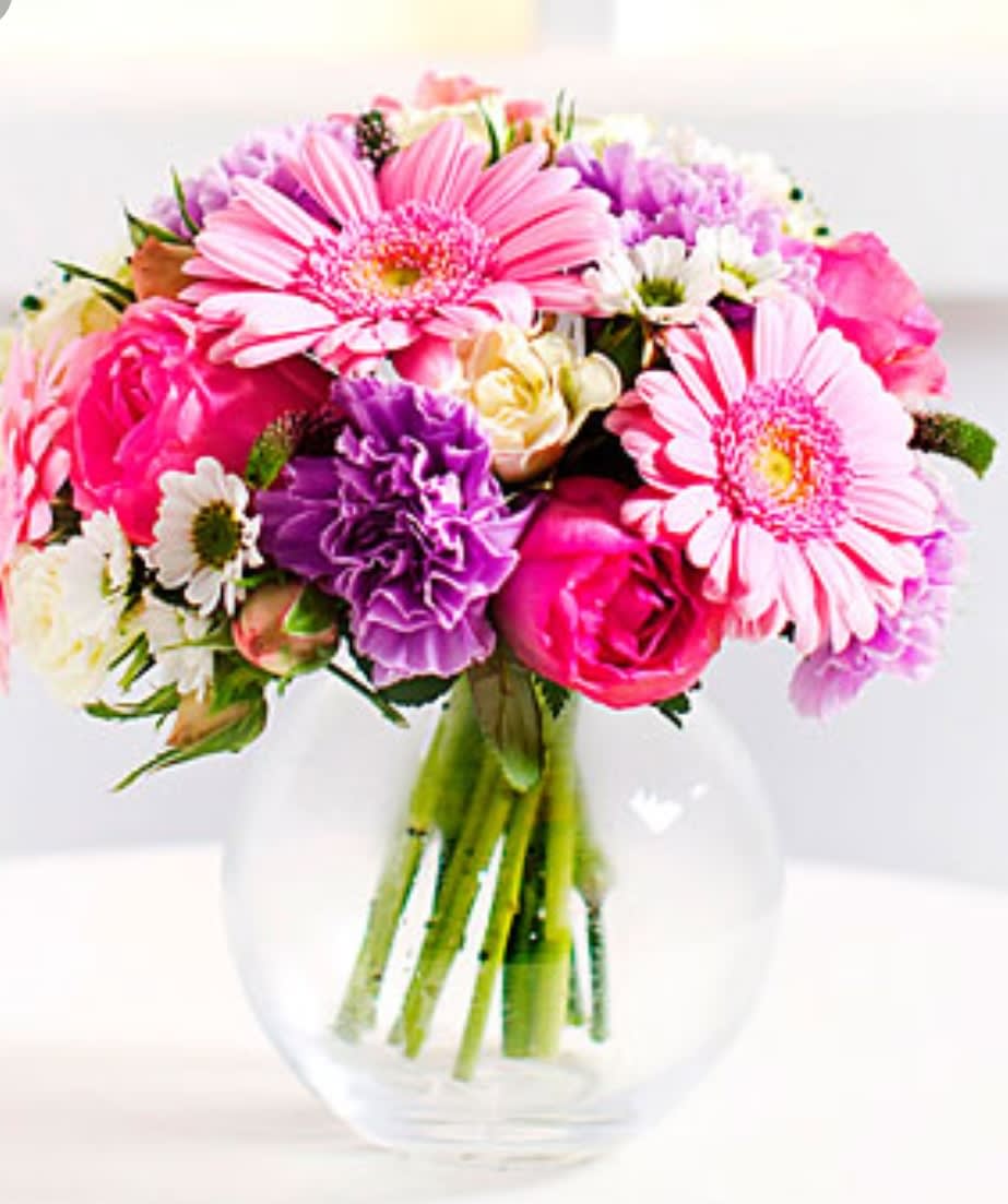 Glamorous Gerberas - This beautiful mixed arrangement designed using Gerberas, Roses,  Carnations, lush greens and filler, in a variety of fun colors.  Deluxe version pictured.
