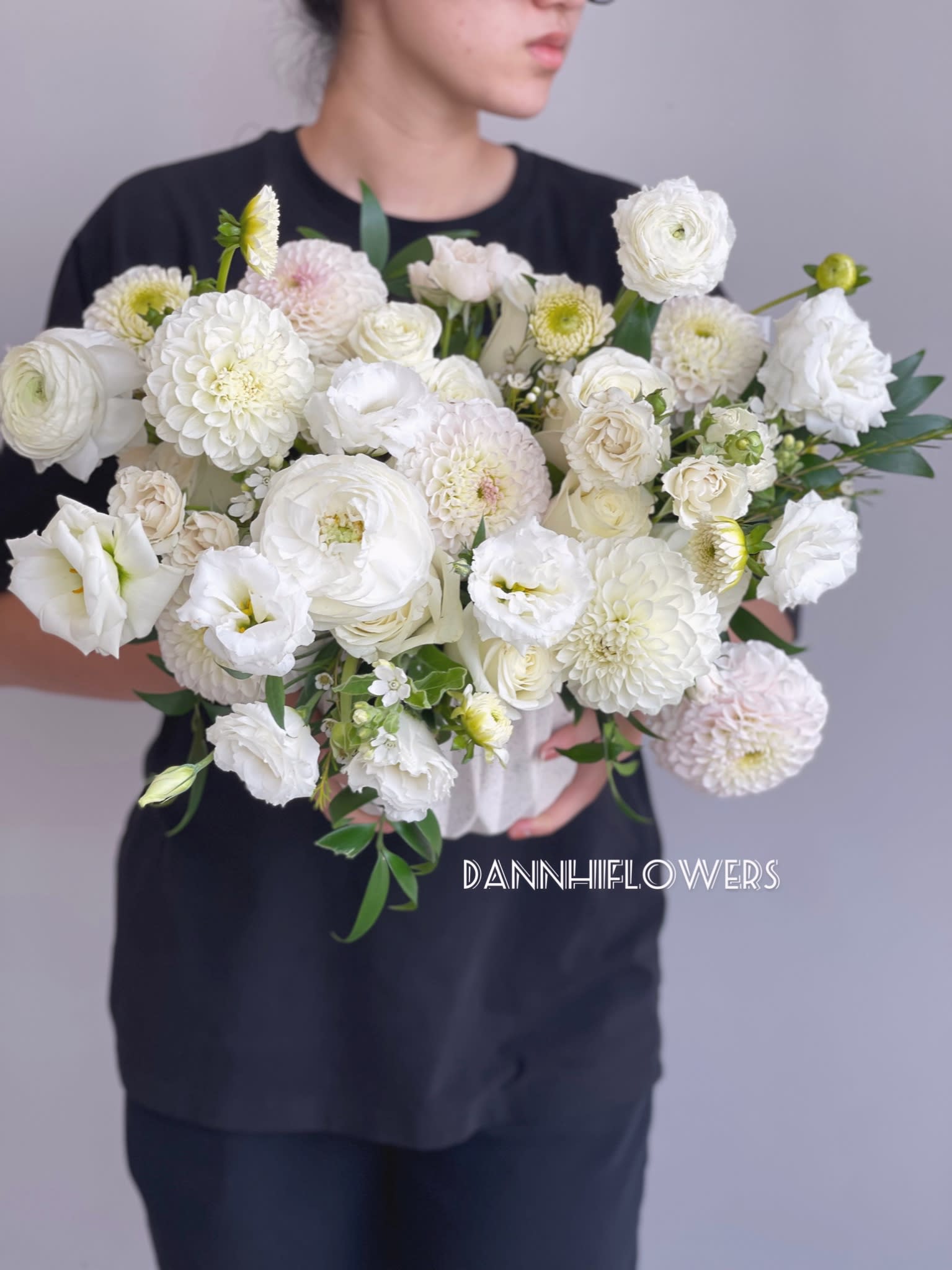 White on white - A seasonal mix of white dahlias and white roses, lisianthus in a modern style/vase arrangement. The blooms used may vary by the season and availability, and since each arrangement is custom-made to order by our talented designers, they will all look slightly different, which is what makes them so special! The photo is a representation of overall vibe of our signature arrangement.  The photo is at Standard size. Deluxe size will be bigger.