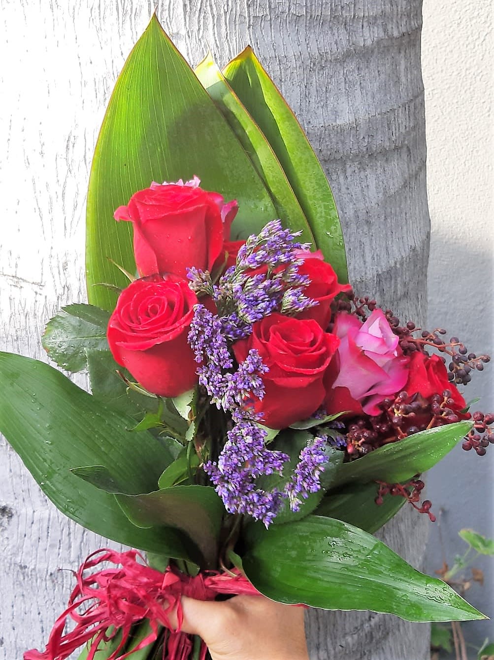 Hand Tied Modern Bouquet - For Valentines: a bohemian display of red and purple roses with a tropical flow.
