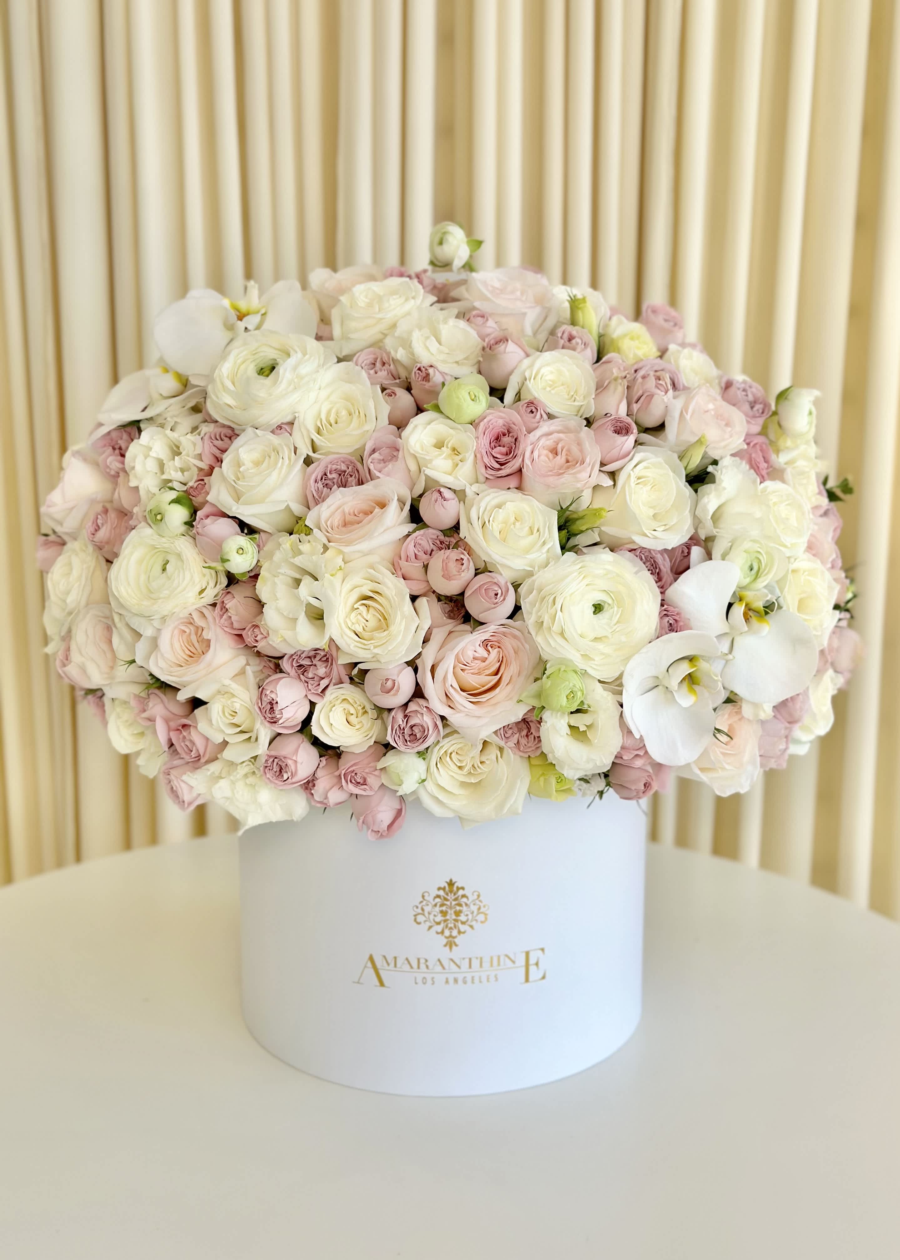 Pink and White Floral Serenity - Welcome to the world of &quot;Pink and White Floral Serenity,&quot; where the gentle allure of nature's finest blooms meets the tranquil sophistication of a pristine white box. This enchanting arrangement is a symphony of soft, romantic pinks and crisp, pure whites, meticulously curated to captivate your senses and evoke profound emotions.  Our skilled artisans delicately hand-pick each flower, ensuring unrivaled freshness and quality. With an artist's touch, they arrange these blooms to create a masterpiece that exudes purity and grace.  Whether you're commemorating a special occasion, conveying your deepest sentiments, or simply brightening up your space, &quot;Pink and White Floral Serenity&quot; is the perfect choice. This timeless creation speaks volumes of love, appreciation, and friendship.