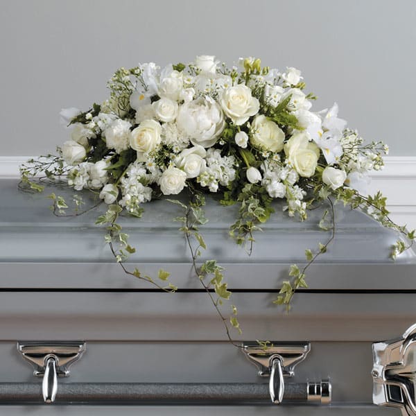 Loving Memories Casket Spray - A pure white, loving tribute created with roses, iris, tulips, carnations and tenderly trailing ivy.
