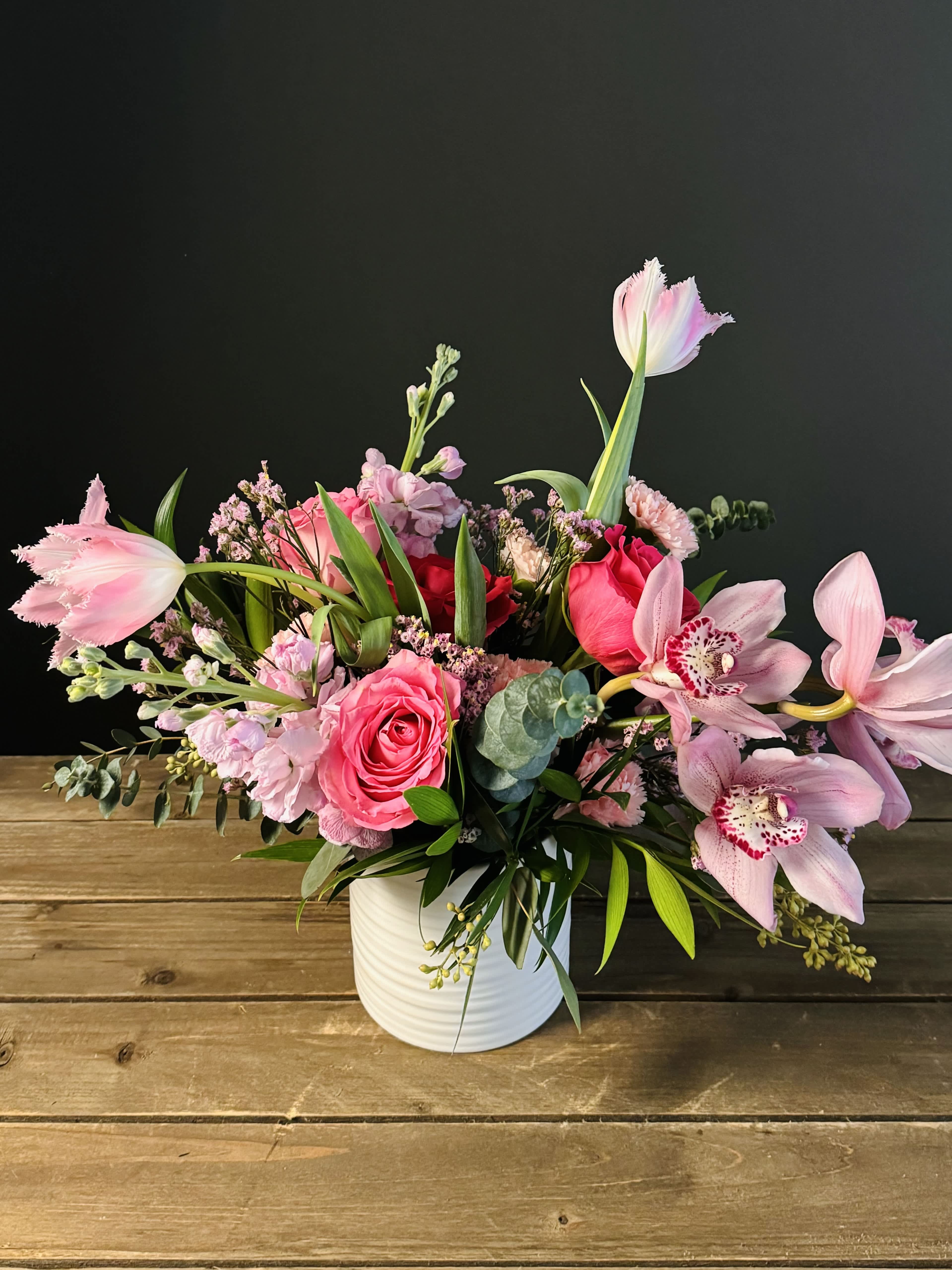 Rhapsody in Pink - An ecstatic expression in pink materializes in this colorific bouquet featuring locally grown tulips, roses, and cymbidium orchids. Pink hues come from combining the passion of the color red and white's purity. It symbolizes love, nurture and compassion. It evokes feelings of comfort, warmth and hope. Pink is also a sign of good health with the phrase “in the pink.” It symbolizes success in the expression that “everything is rosy” and happiness with “tickled pink.” Wether you gift this arrangement to your special someone  or yourself; you will be sure to express a rhapsody of emotion right from your heart. We believe flowers always have a way to express what words cannot.  