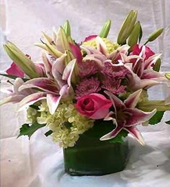 My Love Deluxe - Hot Pink roses with stargazer Lilies accented with Hydrangeas. Arranged in a glass cube. The quantity of flowers increase with Deluxe and more for Premium. 