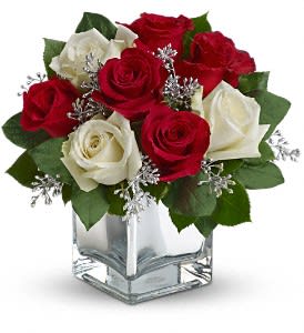 Teleflora's Snowy Night Bouquet - The perfect Christmas hostess gift, this exciting bouquet of red and white roses in a dazzling mirrored cube is guaranteed to make spirits brighter. Simple, stylish, affordable ¬- better order one for yourself as well.  The delightful holiday bouquet features red roses and white roses accented with assorted greenery.  Approximately 11&quot; W x 10 3/4&quot; H  Orientation: All-Around  As Shown : T407-2A Deluxe : T407-2B Premium : T407-2C