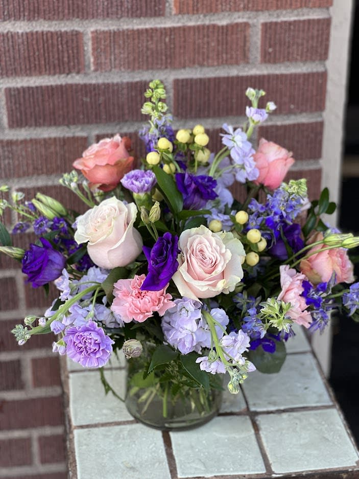 Champagne &amp; Violets - Designed by one of our local girls, this soft arrangement in peaches, lavendars and purples is presented in a glass cylinder. :)  Larger sizes add more roses and stock. 