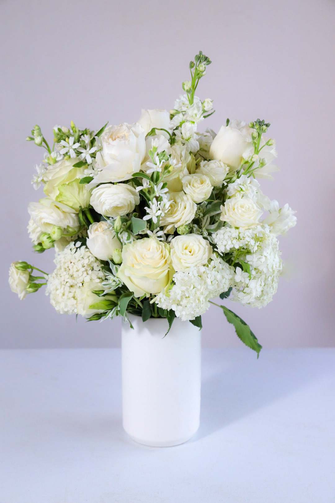 The Ivory &amp; Linen Arrangement - The Ivory &amp; Linen Arrangement could be found in a Merchant Ivory film, an English Countryside Manor or a wedding chapel. Appropriate to speak of sorrow or significance, and also for those that like the crisp, clean palette of gradients of white.  Elegant and distinguished.   Custom, one of a kind floral arrangements by floral artist Stacy Leafsong.  Photos provide examples, and each arrangement &amp; vase is unique.  Arrangements will be delivered before 7pm, for specific delivery time please include in special instructions. On holidays, our busiest times, deliveries will be made by 7:30pm.
