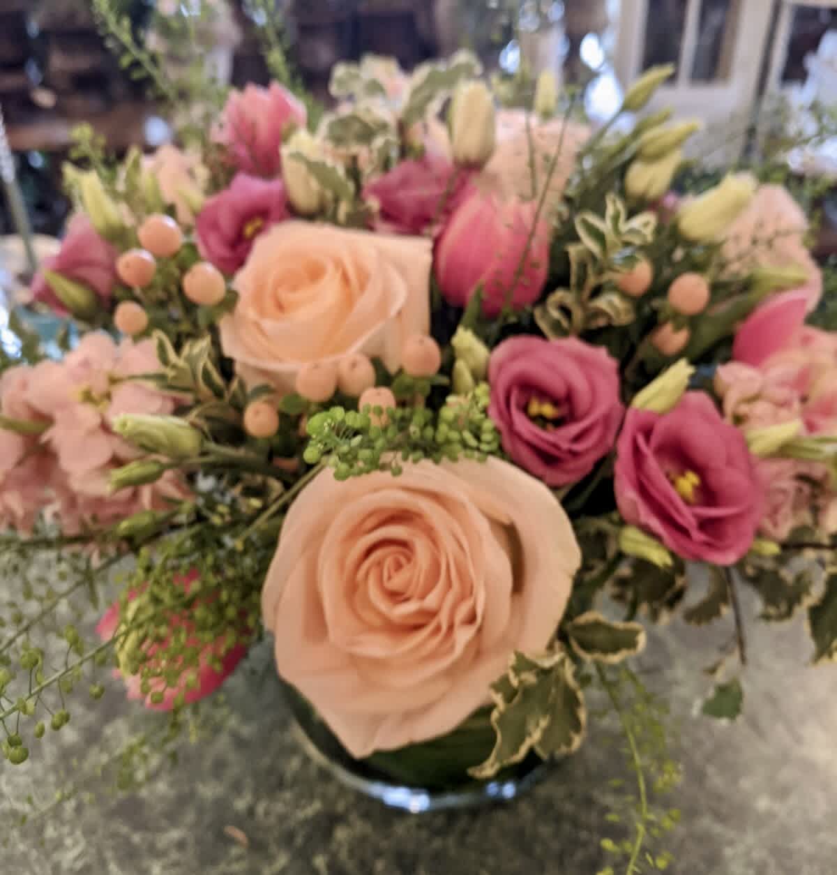Peachy Pink 6x6 Cylinder Vase - Lovely mix of peach and pink flowers include Peach roses, stock, hypericum berries, Columbus tulips and Lisianthus. Perfect for any occasion.