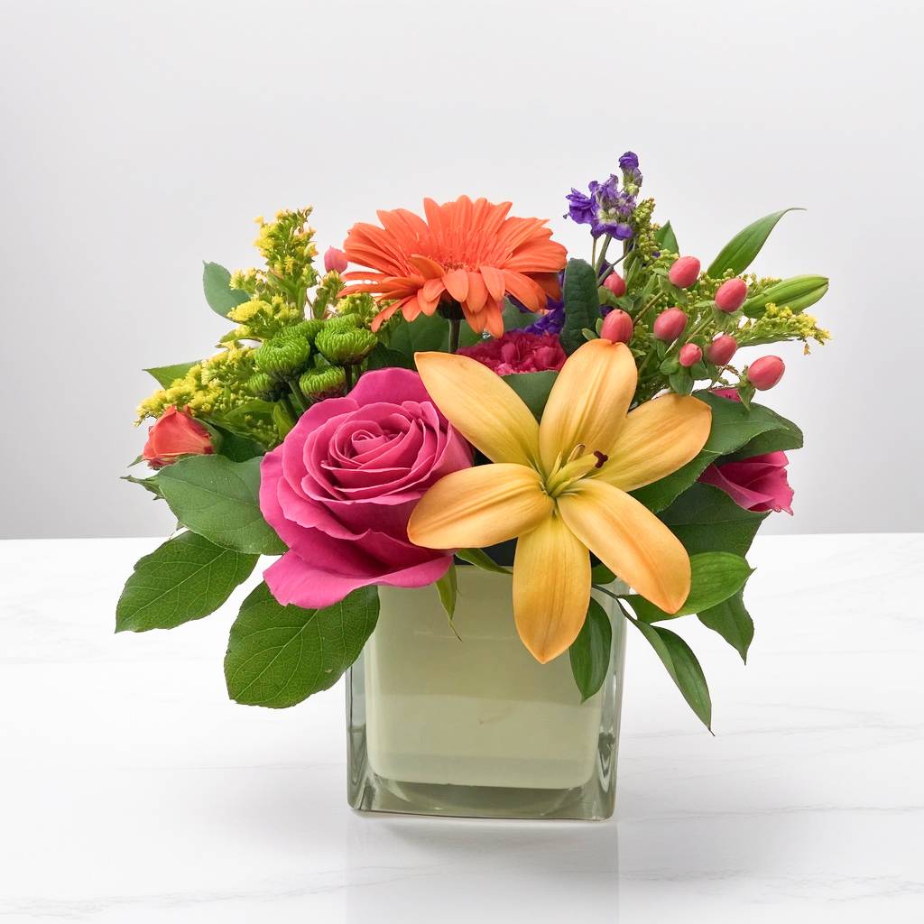 Happy Hues - The world is full of color, and so are our fresh flower arrangements! A Hignight's exclusive, this gorgeous selection features the vibrant, cheerful hues with a lily, , gerbera daisy, and roses, all nestled in an opaque pastel glass cube. Each flower is hand-picked and arranged with love and care to ensure the highest quality and freshness. This arrangement is perfect for brightening up any room or for making someone's day extra special.  Embracing the beauty of change: the color of these pastel cubes may vary with availability, but their charm remains constant.   Remember, every petal tells a story and we are here to help you tell yours.  Local flower delivery to the Quad Cities area is a convenient and timely service offered by our flower shop. We take pride in delivering beautiful floral arrangements to Davenport, Bettendorf, Rock Island, Moline, East Moline, Silvis, Hampton, Colona, Carbon Cliff, Coal Valley, and Milan. Whether you want to surprise a loved one or brighten someone's day, our efficient delivery service ensures your flowers arrive fresh and vibrant. Experience the joy of gifting flowers with our reliable local delivery service in the Quad Cities area.